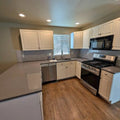 White kitchen cabinets , quartz countertop, refrigerator , sink, dishwasher, and microwave. in Kersey, CO