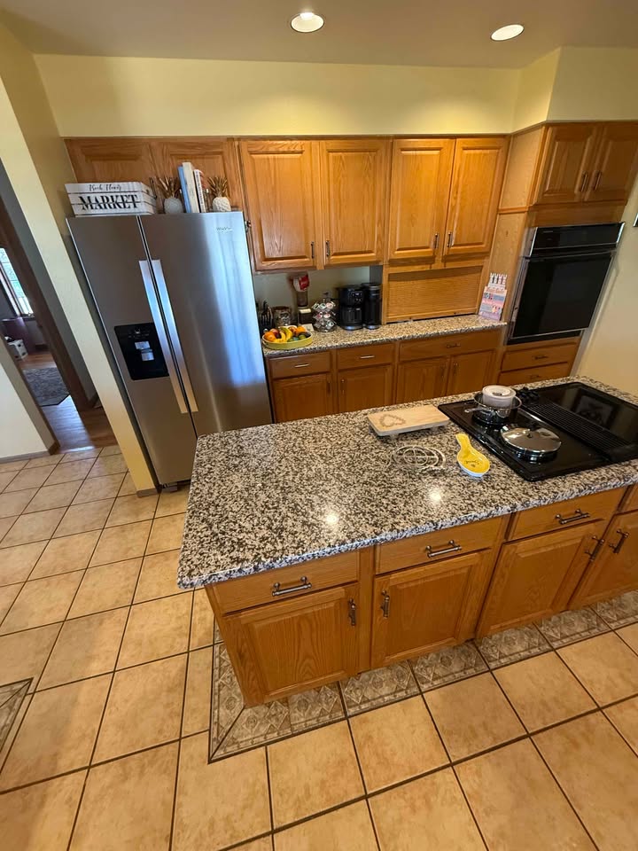Full kitchen. Cabinets, granite, sink, cooktop, oven, and microwave.