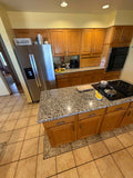 Full kitchen. Cabinets, granite, sink, cooktop, oven, and microwave.